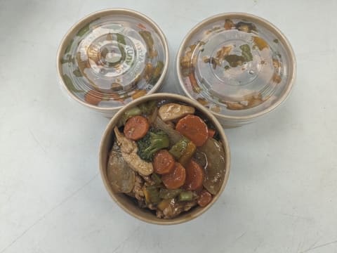 Take-home containers with stir-fry vegetables and chicken