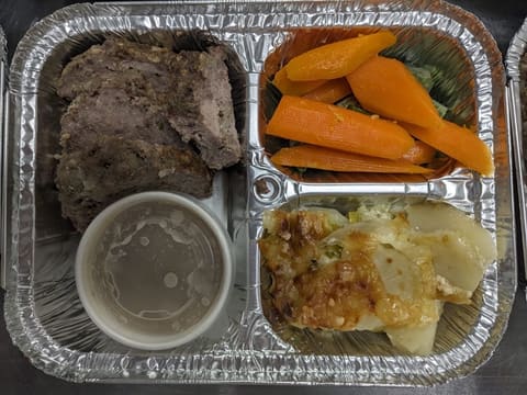 Frozen dinner tray with meatloaf, glazed carrots, and potato gratin